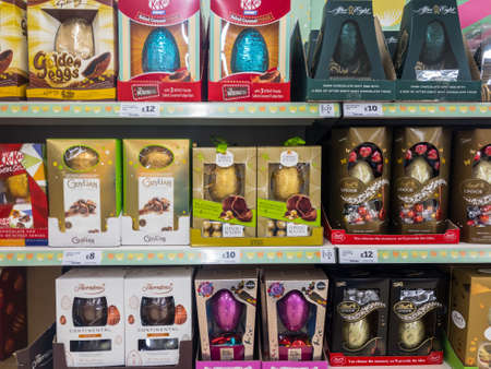 Exeter, Devon , England, March, 14, 2019: A UK supermarket filled shelves selling large and expensive chocolate Easter Eggs. Lots of purple and red in the image, horizontal aspectのeditorial素材