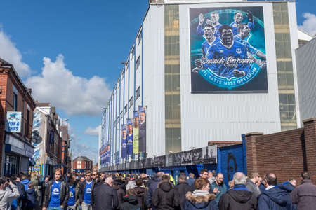 Everton, Liverpool, UK, April, 17, 2016: Crowds supporters gather at Everton Football Club for a premiership game, flags and scarfs in the Everton colours can be seen, against a bright blue skyのeditorial素材