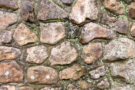Close up of an old stone wall with little bits of moss and weeds, perfect for backgrounds and abstracts imagesの写真素材