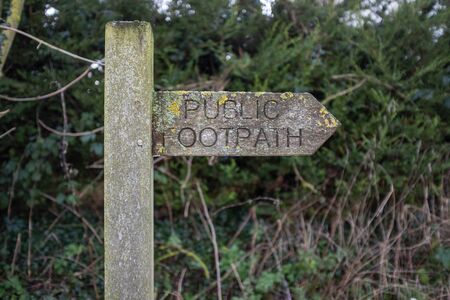 A public footpath sign close up, with green foliage in the backgroundの写真素材