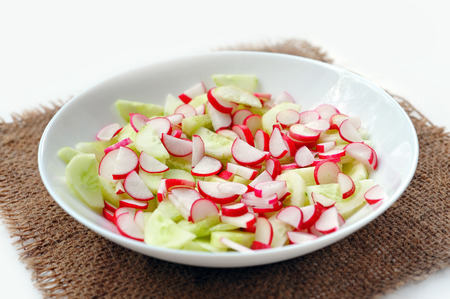 Fresh salad in plate at sackcloth on white background. Not isolatedの写真素材