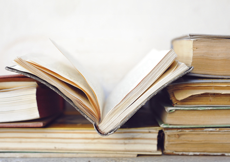 Old opened book at stack of books. Light tone. Selective focus. Copyspace for your textの写真素材