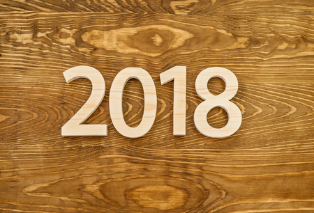 Wooden figures forming 2018, carved from light wood on the background of old wood. New Year Idea,...