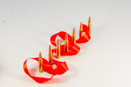 Rifle bullets. Brass Sleeve. With a red ribbon. On a white backgroundの写真素材