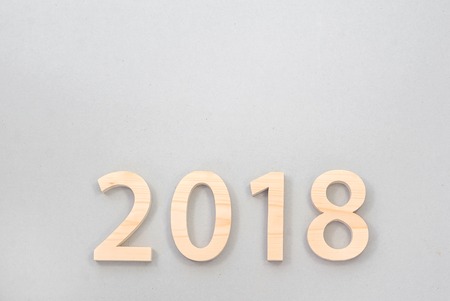 2018 Happy New Year, numbers cut from light  wood on a gray background