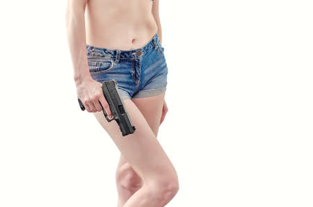 Girl holds a black pistol in her hand.の写真素材