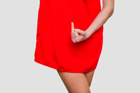 Woman in red dress shows hand gesture sex.の写真素材