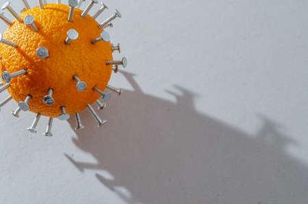 Close-up concept of virus is depicted in form of orange with wood screws