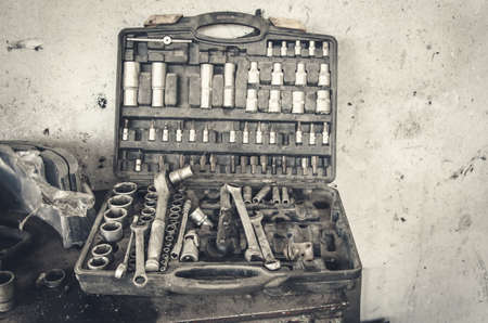 Old set of wrenches for repair in a dusty box on a tableの写真素材