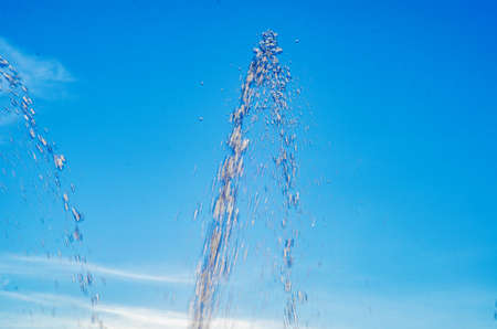 Water jet of fountain on blue sky background.