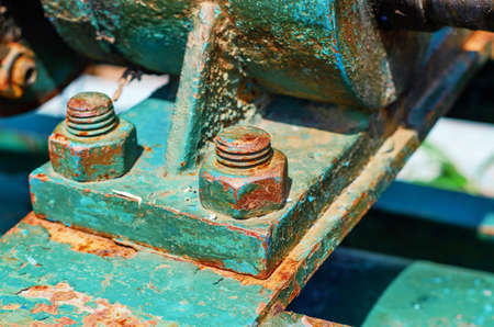 Rusty metal bolts and nuts on metal mounts. Abandoned equipment.の写真素材