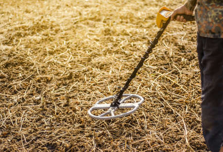 Man is looking for metal objects, a treasure buried in ground with a metal detector. Sensitive metal...