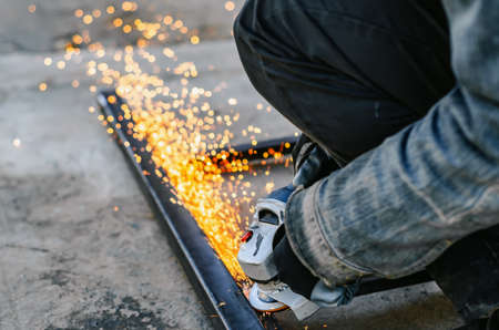 Metal cutting with electric circular saw. Sparks fly in different directions .. Blurred focusの写真素材