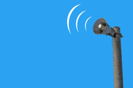 Outdoor loudspeaker on pole against the background of blue sky, sound waves.の写真素材