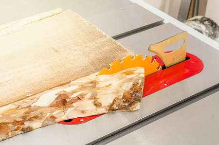 Cutting the board on a circular saw in a woodworking workshop