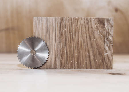 Little circular saw on the background of wooden bars. Workshop. Manufacture of wooden products....