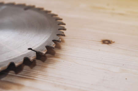 Circular saw on a wood background. Workshop. Manufacture of wooden products. Joiner's cutting toolの写真素材