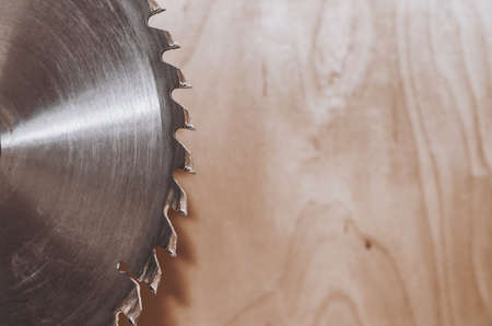 Circular saw on a wood background. Workshop. Manufacture of wooden products. Joiner's cutting toolの写真素材