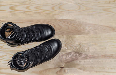 Military shoes boots on background light polished board. Uniform, protection of soldiers, reliable...