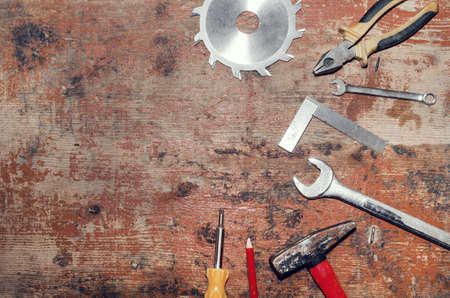 Flatly composition carpentry tools on old board, hammer, pliers, circular saw.の写真素材