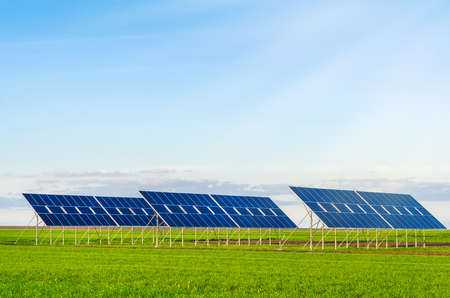 Solar panels in a field on green grass. Environmentally friendly.