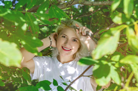 Portrait of young woman among green leaves.の写真素材