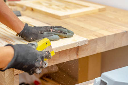 Manual sanding of wooden products. Hands of master