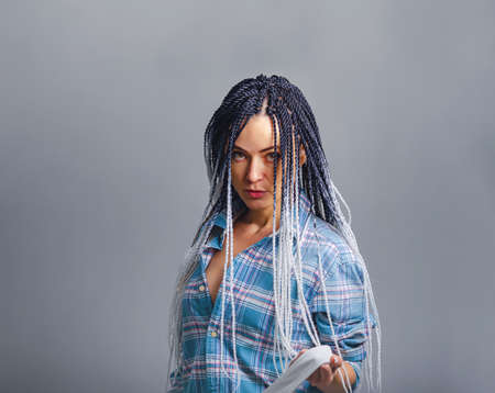 Creative dreadlock hairstyle. Portrait of graceful woman with white afro braids in checkered shirt.....