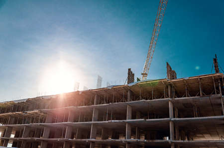 Concrete structures in sunlight. Construction of multi-storey buildings. Crane.