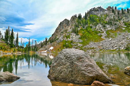 Mountain lake, a rock above the lake in mountains