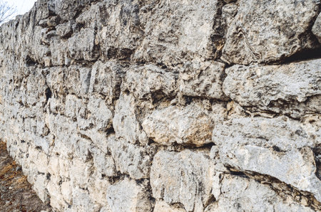 Paved wall with rough, clear texture and deep lines between large stones. stone wall.の写真素材