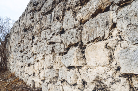 Stone wall. Paved wall with rough, clear texture and deep lines between large stones.の写真素材