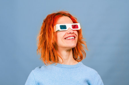Cheerful young woman in 3D glasses. blue background