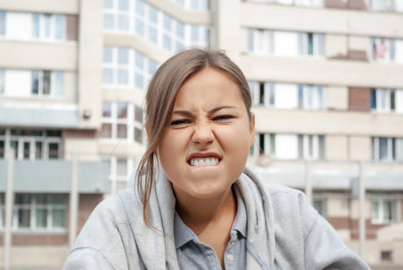 Cheerful young girl. Makes funny facial expressionsの写真素材