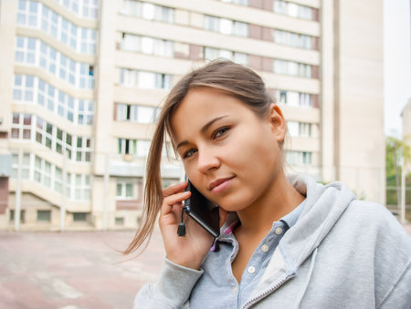 Cute young girl is talking on mobile phoneの写真素材