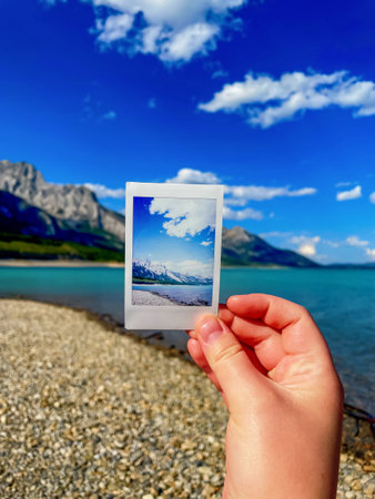 Woman hand holds photo of sea bay on background of bayの写真素材