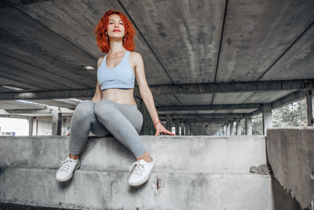 girl in sport clothes and her sole shoe from under. sporty female exercise on bridge background. low angle shutting.の写真素材