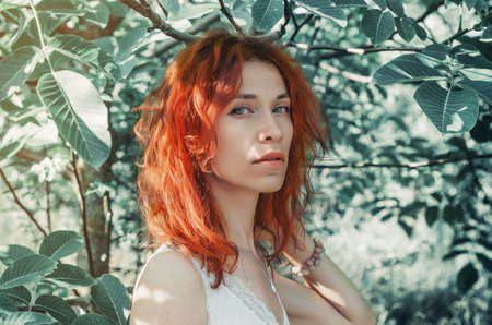 Portrait of a red woman among the nut leaves in the summer in the gardenの写真素材