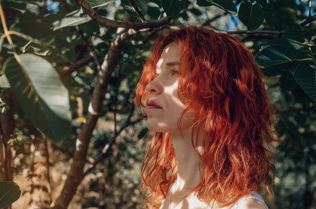Portrait of a red-haired young girl among the trees in the gardenの写真素材