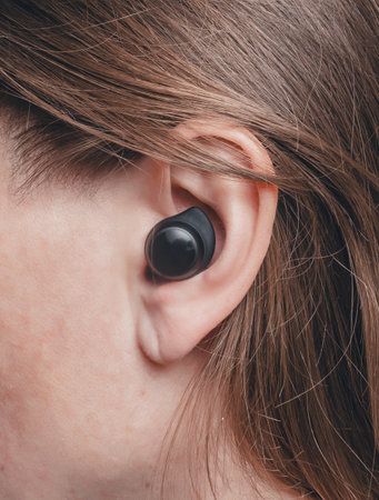 Wireless earbud in women ear close-upの写真素材