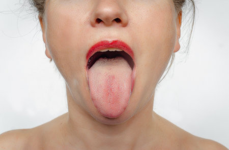 Front view of womans face with her tongue sticking out. Treatment of ENT diseases.の写真素材