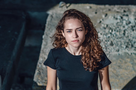 Top view of a charming young woman's face. Wavy hair, black T-shirtの写真素材