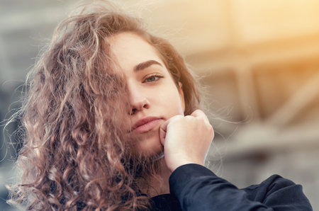 Portrait of a cute girl with long curly hair looking down at camera, nice smile.の写真素材