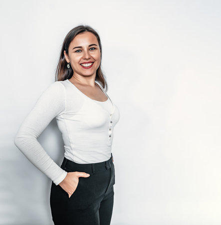 Bright smile on face. Confident business woman in white sweater and black pantsの写真素材