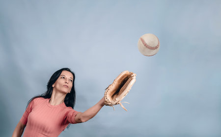 A woman catches a ball with a baseball glove