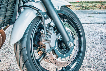 The front wheel of a racing motorcycle on road.の写真素材