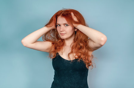 Portrait of girl with red tousled hair in black short dress. Cosmetics, makeup, hair care.の写真素材