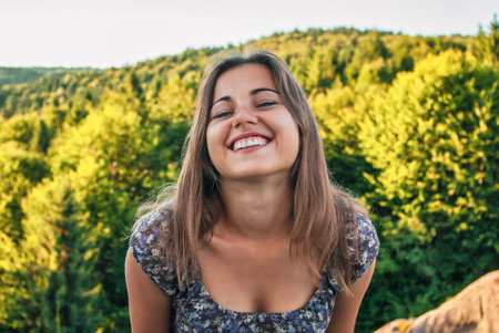 Girl smiles at the camera against the background of the forest in nature. smile, joy, journeyの写真素材