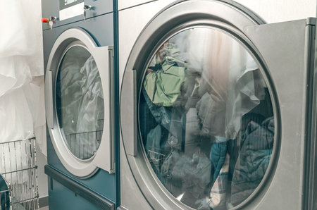 Dry cleaning dryer. Two dryers loaded with clothes are operating in dry cleaning room.