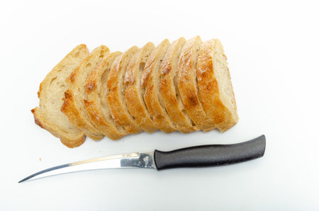 Slices of fresh bread and cutting knife on white background, isolated. Healthy proper nutrition.の写真素材